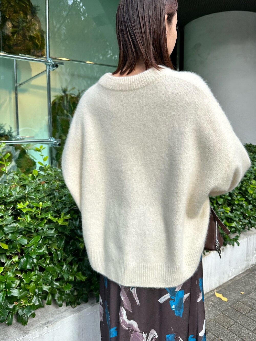 ホワイト系のニット/セーター、ブラウン系のスカート、ブラウン系のボストンバッグを着用したレディースの秋コーディネートの6枚目の写真