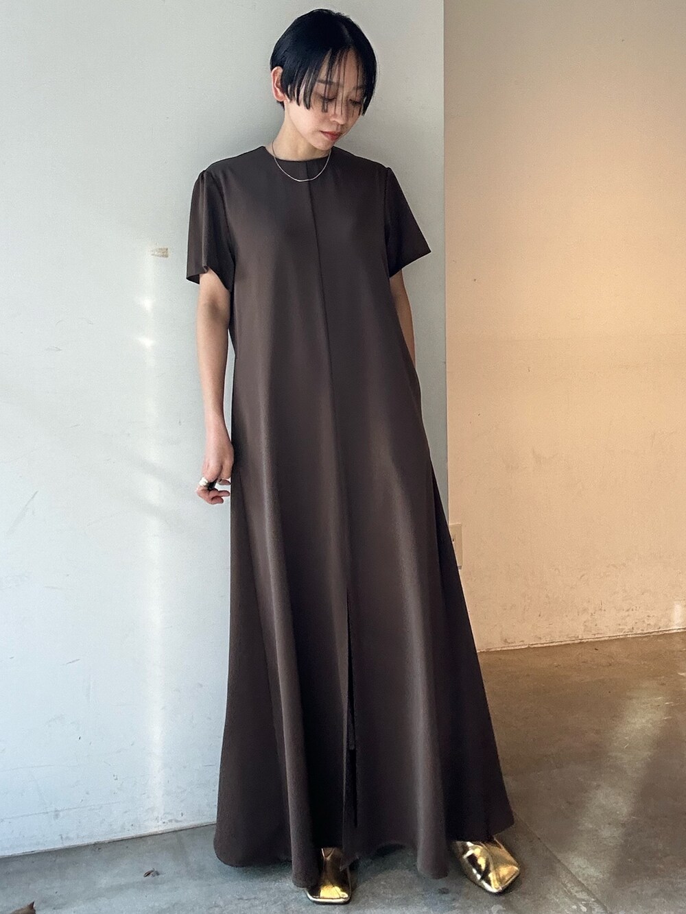 ブラウン系のワンピース、ゴールド系のパンプスを着用したレディースの春コーディネートの5枚目の写真