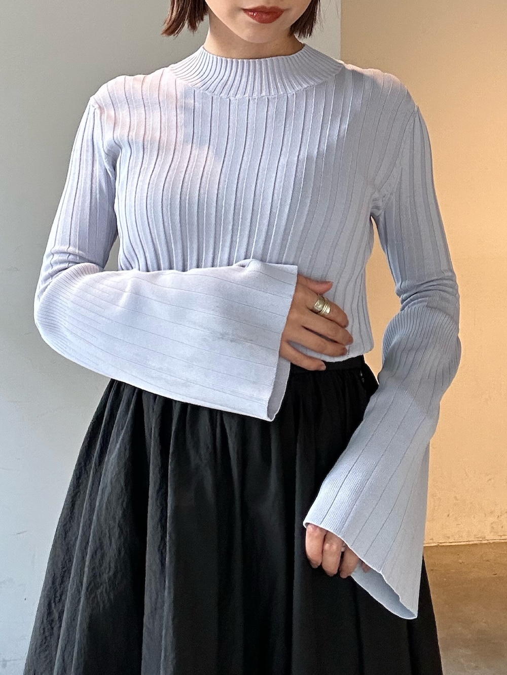 ブラック系のスカート、ブラック系のブーツ、パープル系のニット/セーターを着用したレディースの冬コーディネートの8枚目の写真