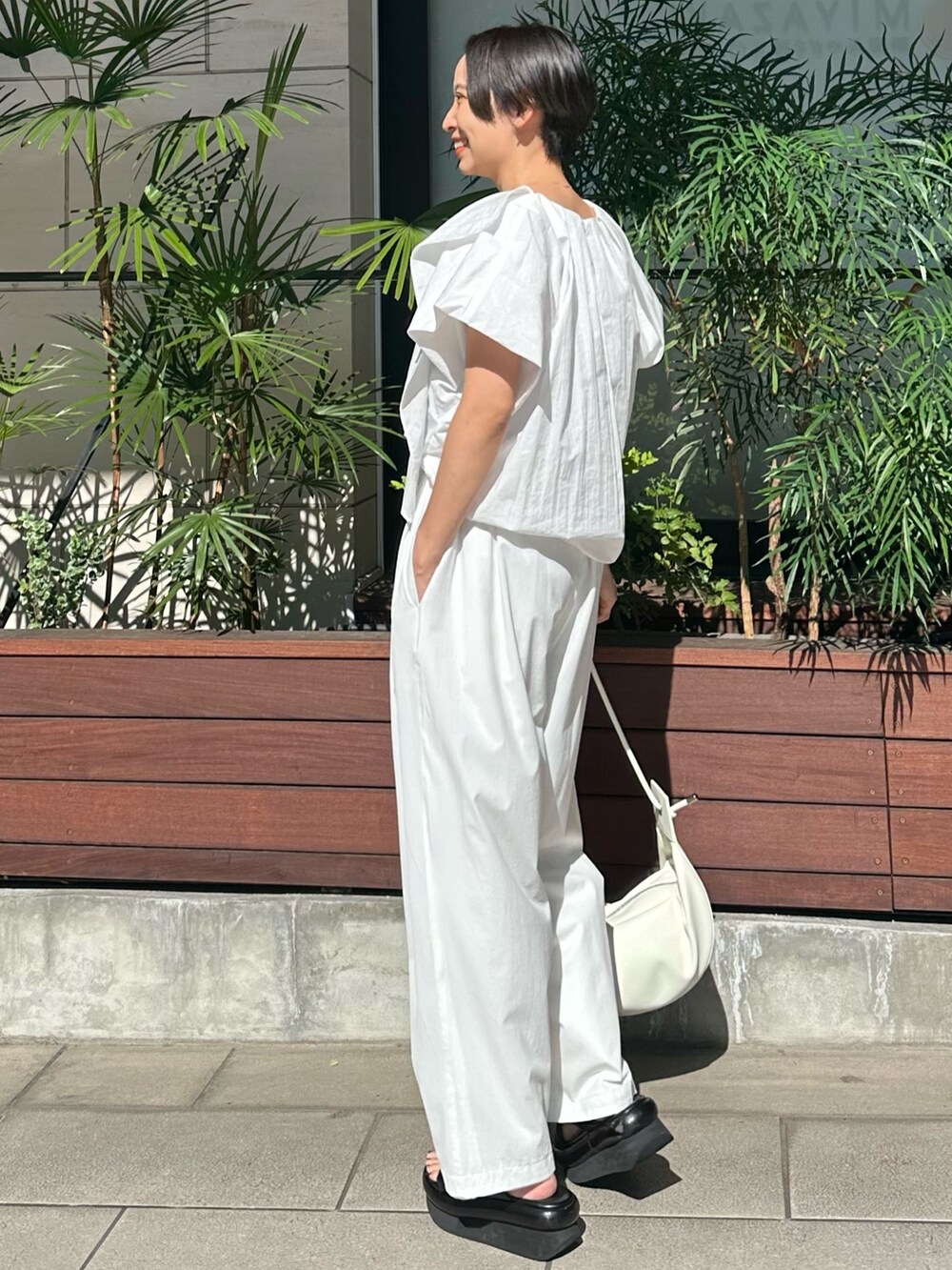 ホワイト系のシャツ/ブラウス、ホワイト系のその他パンツ、ホワイト系のハンドバッグを着用したレディースの春コーディネートの3枚目の写真