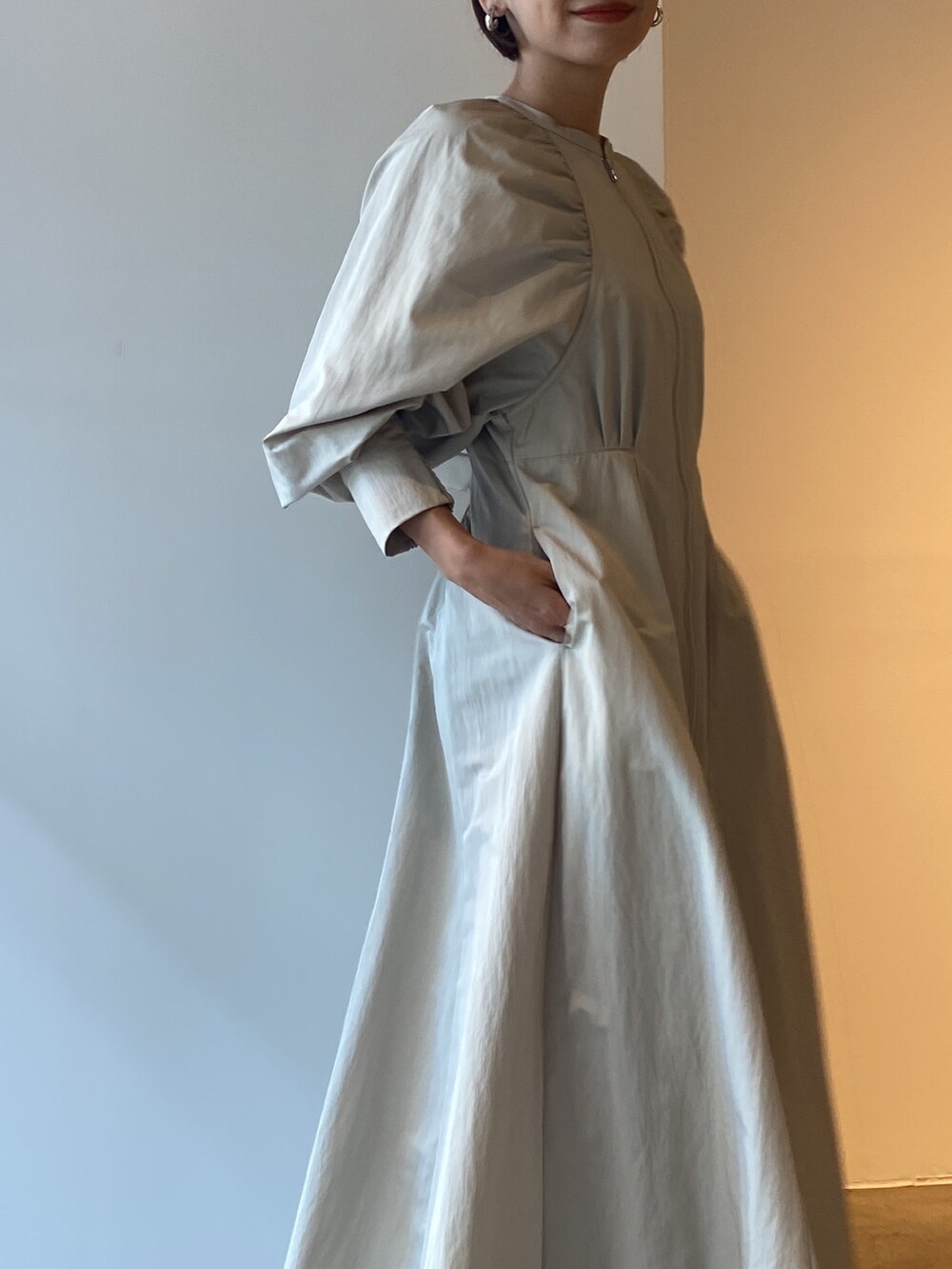 シルバー系のボストンバッグ、ブラック系のブーツ、ベージュ系のワンピースを着用したレディースの冬コーディネートの9枚目の写真