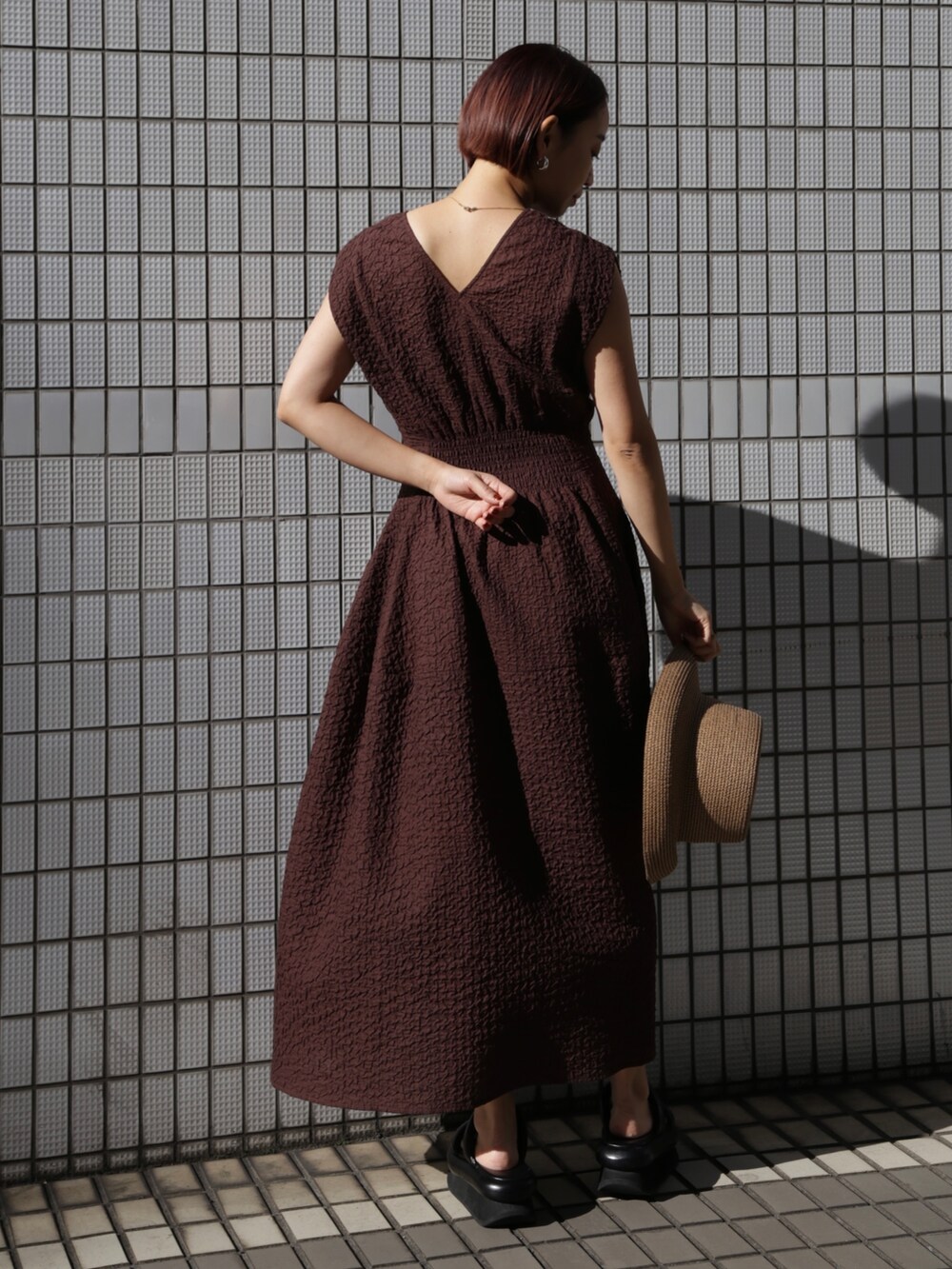 ブラウン系のワンピース、ブラック系のサンダルを着用したレディースの冬コーディネートの5枚目の写真