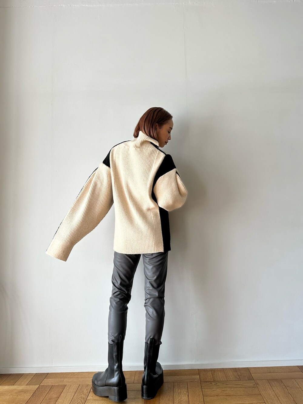 ホワイト系のニット/セーター、グレー系のその他パンツ、ブラック系のブーツを着用したレディースの秋コーディネートの6枚目の写真