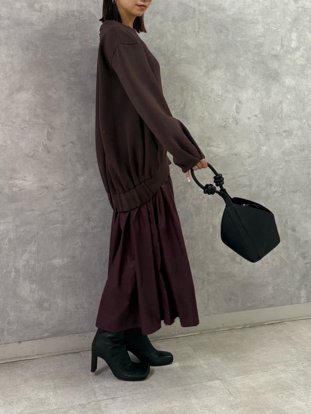 ブラウン系のワンピース、ブラック系のハンドバッグを着用したレディースの秋コーディネートの4枚目の写真