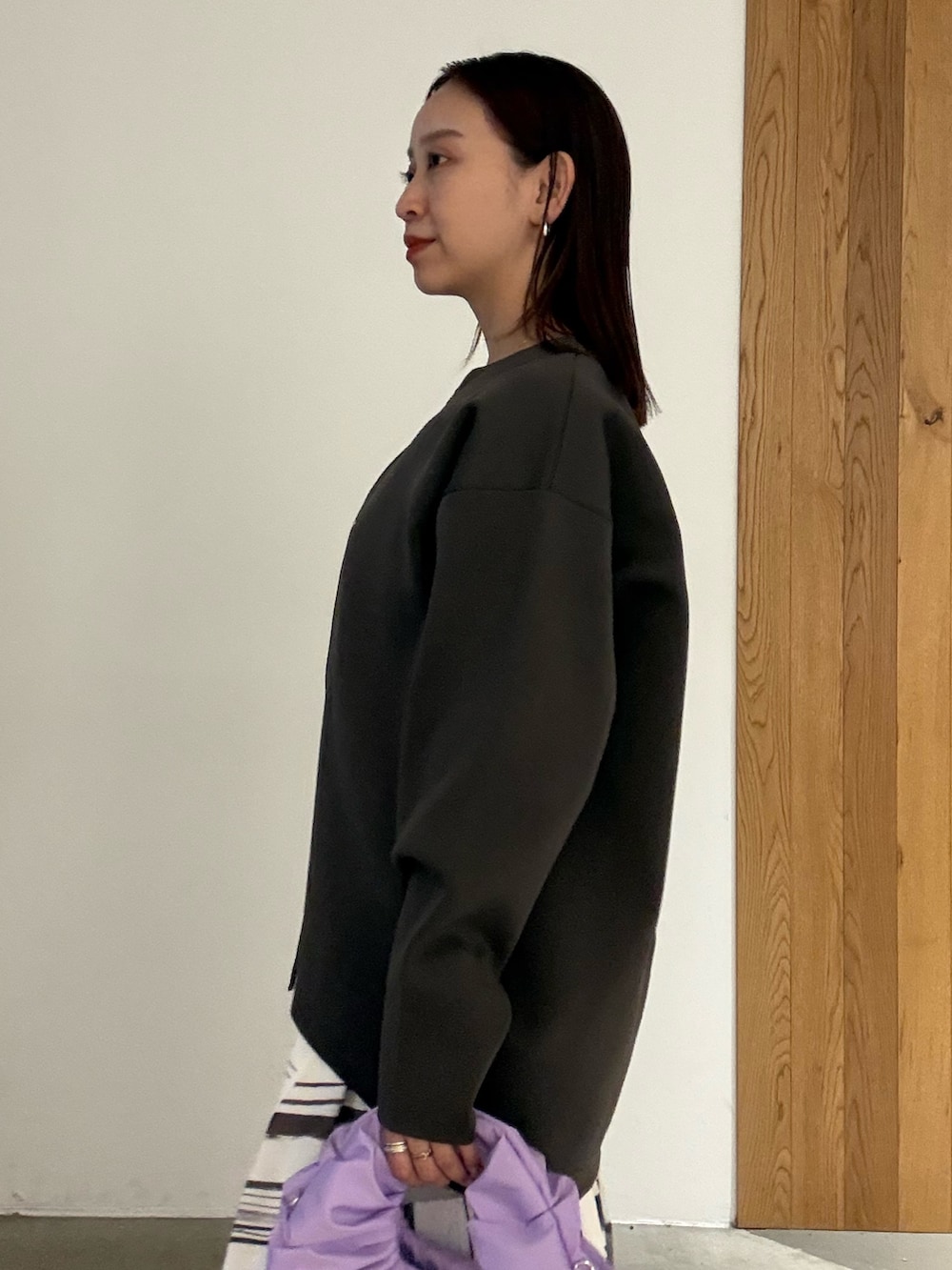 ホワイト系のワンピース、ブラック系のパンプス、パープル系のハンドバッグを着用したレディースの冬コーディネートの5枚目の写真