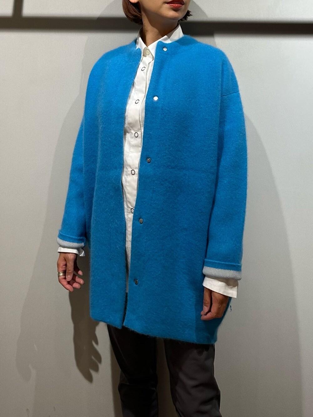 ブルー系のノーカラージャケット、ホワイト系のシャツ/ブラウス、グレー系のその他パンツを着用したレディースの秋コーディネートの3枚目の写真