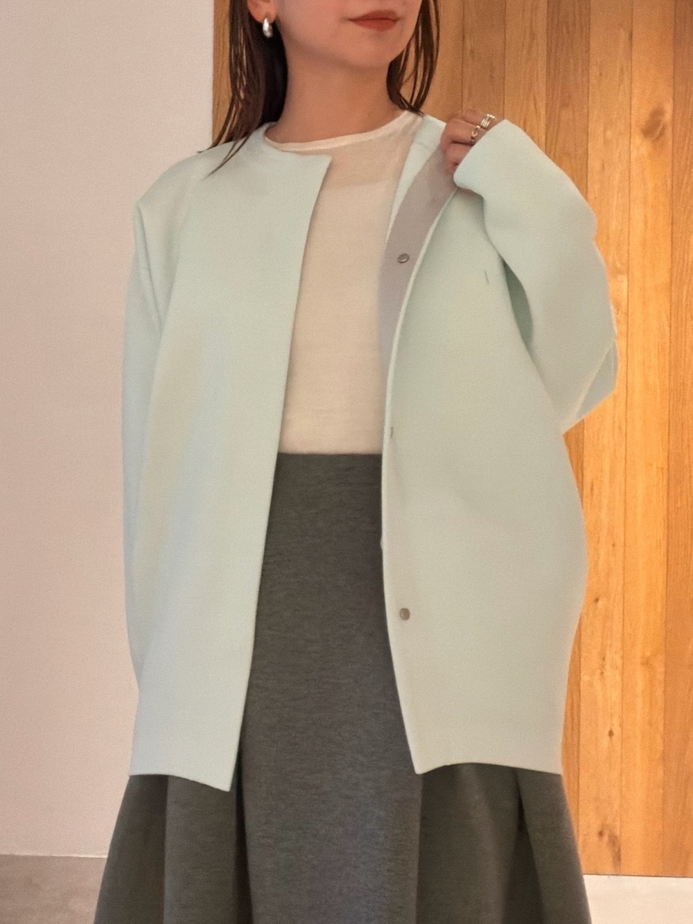 グレー系のスカート、ホワイト系のスニーカー、ホワイト系のハンドバッグを着用したレディースの冬コーディネートの5枚目の写真