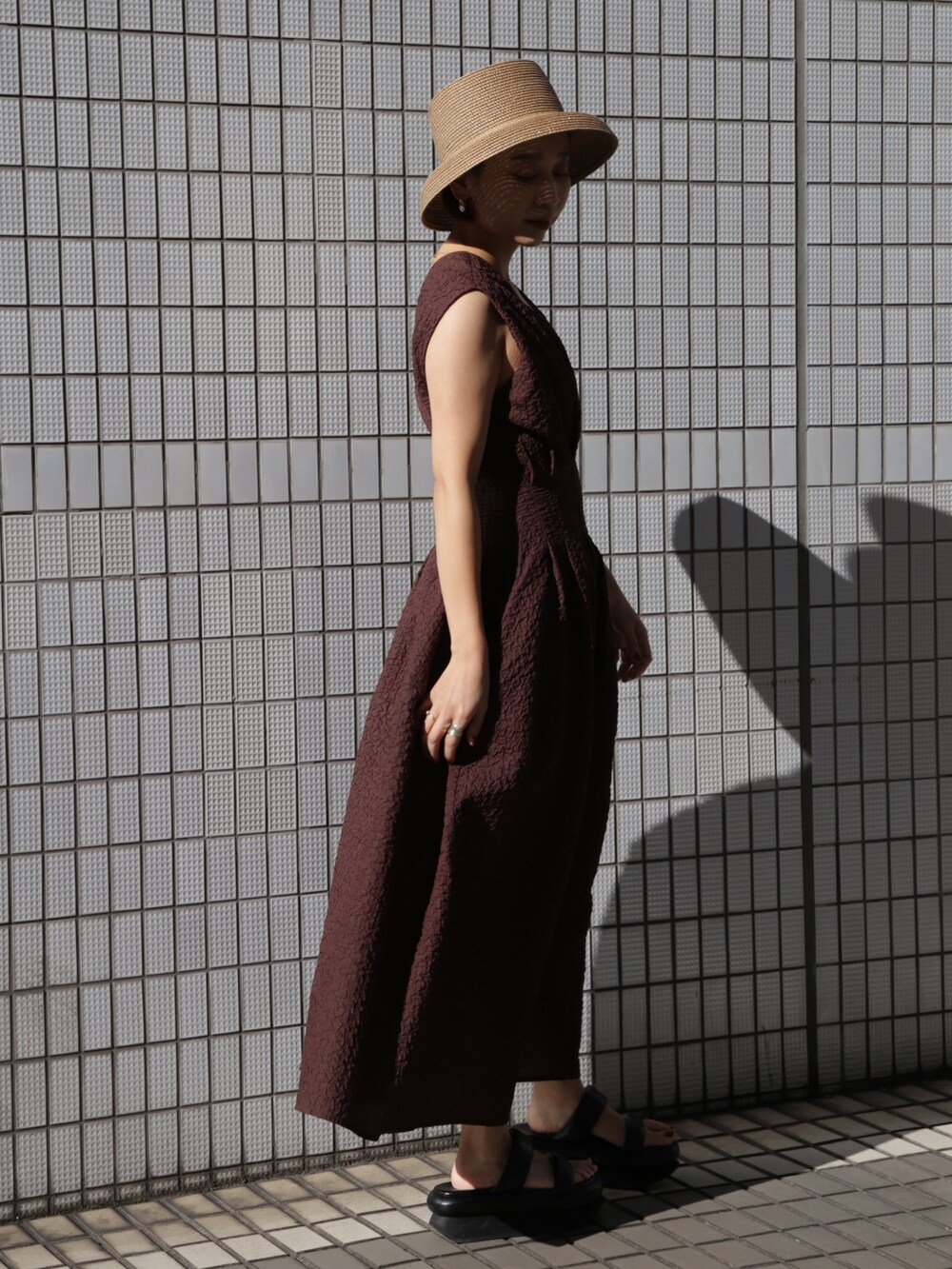 ブラウン系のワンピース、ブラック系のサンダルを着用したレディースの冬コーディネートの3枚目の写真