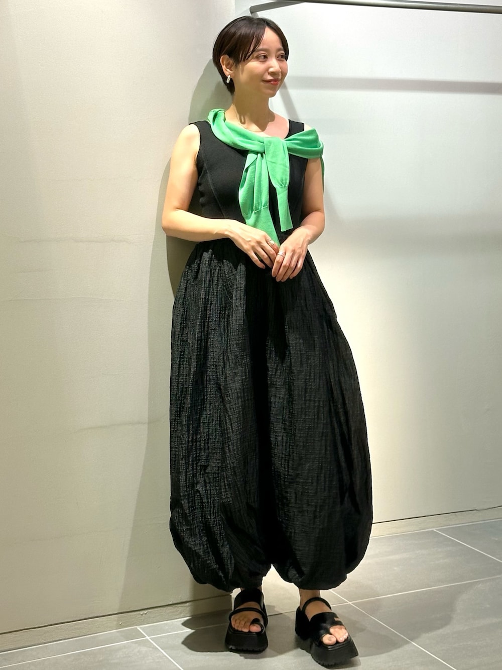 ブラック系のワンピース、ブラック系のサンダル、グリーン系のカーディガン/ボレロを着用したレディースの夏コーディネートの2枚目の写真
