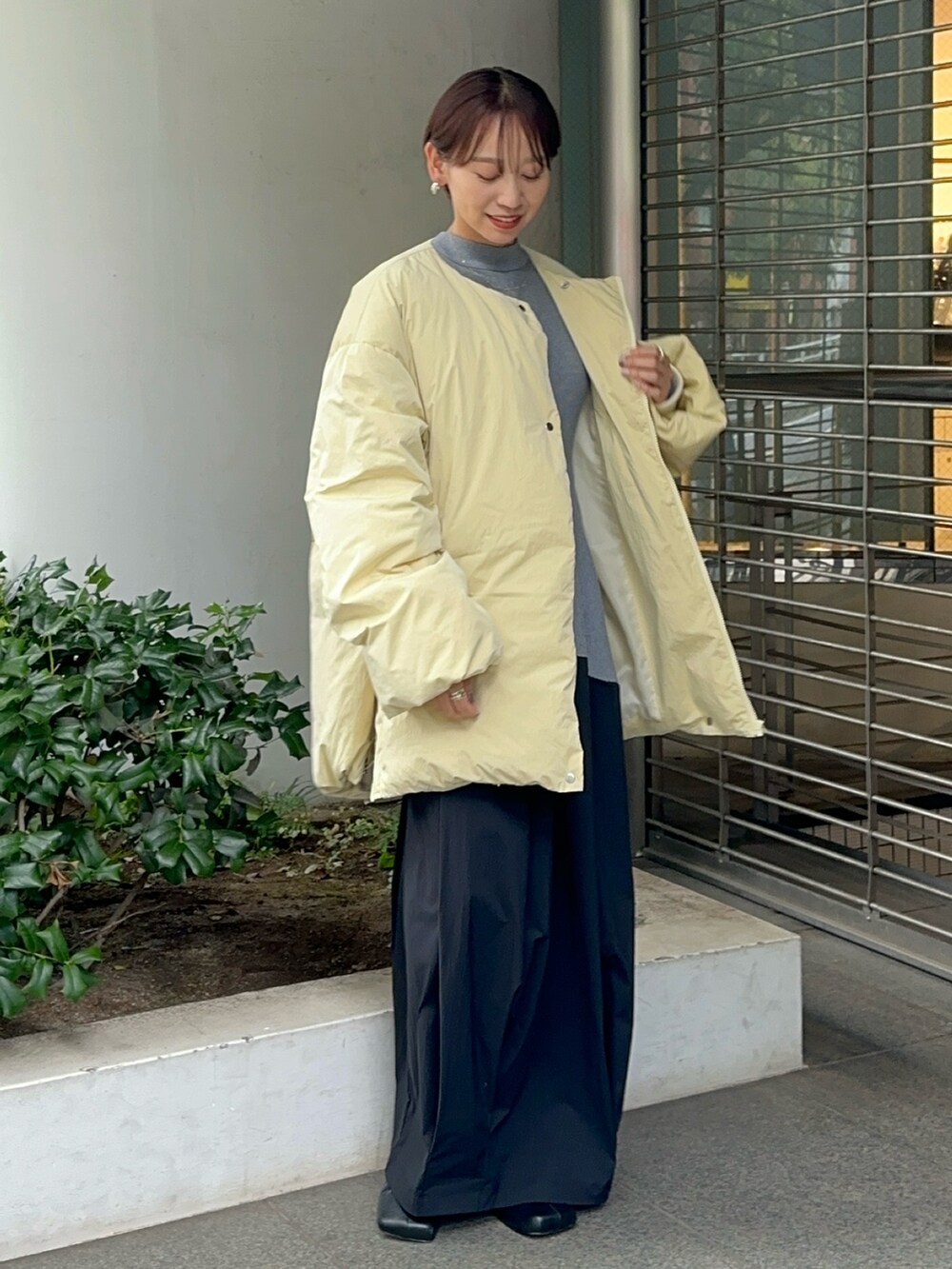 イエロー系のダウンジャケット/コート、グレー系のワンピース、ブラック系のブーツを着用したレディースの夏コーディネートの5枚目の写真