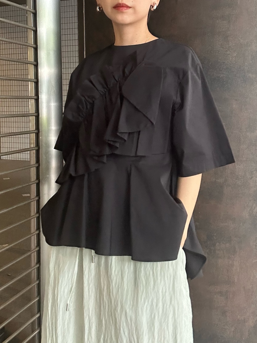 ブラック系のシャツ/ブラウス、グリーン系のスカート、ブラック系のサンダルを着用したレディースの夏コーディネートの5枚目の写真