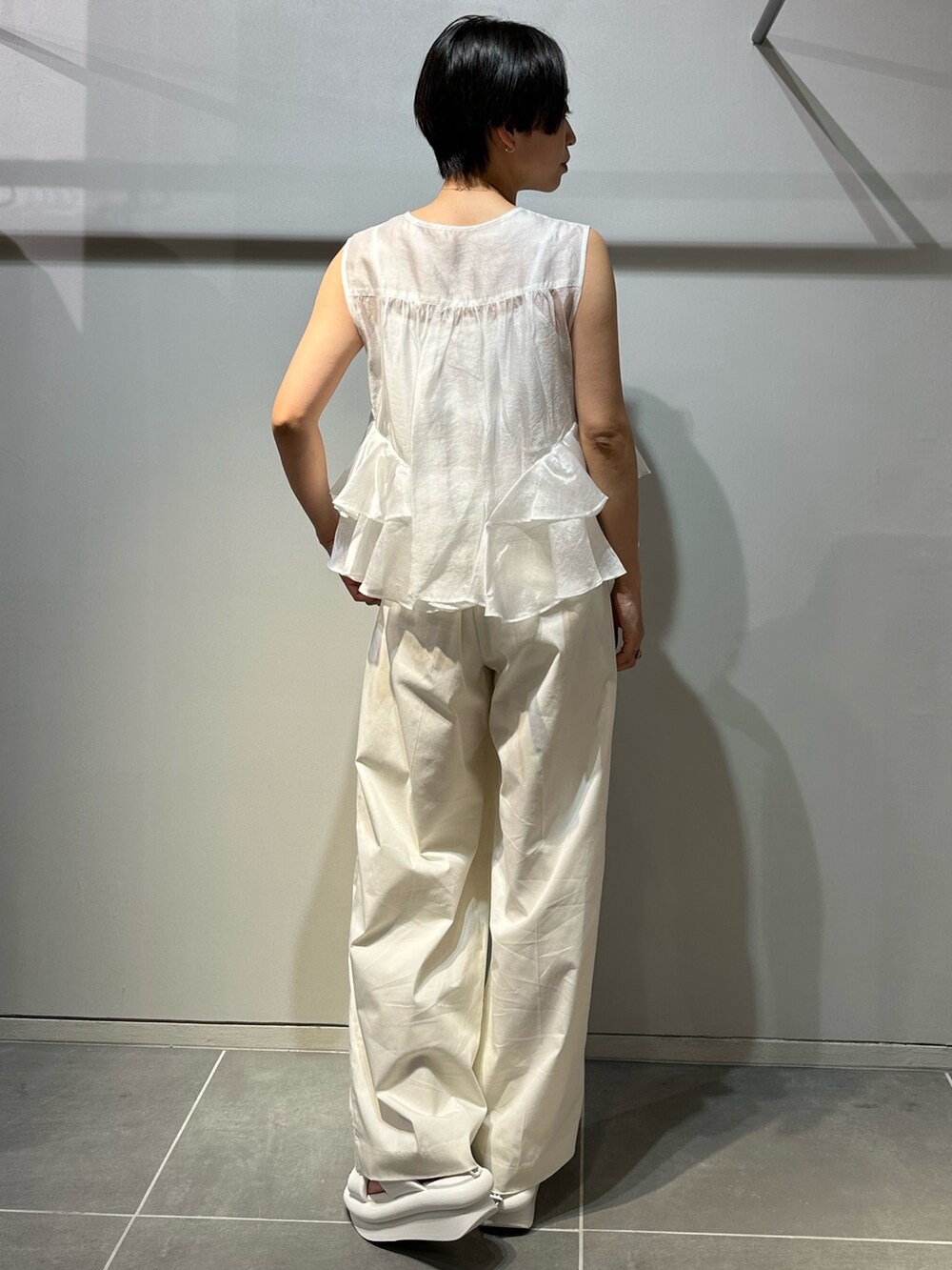 ホワイト系のサンダル、ホワイト系のその他パンツ、ホワイト系のシャツ/ブラウスを着用したレディースの春コーディネートの4枚目の写真