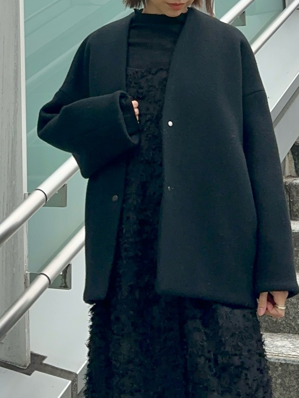 ブラック系のスニーカー、ブラック系のワンピース、ブラック系のニット/セーターを着用したレディースの冬コーディネートの8枚目の写真