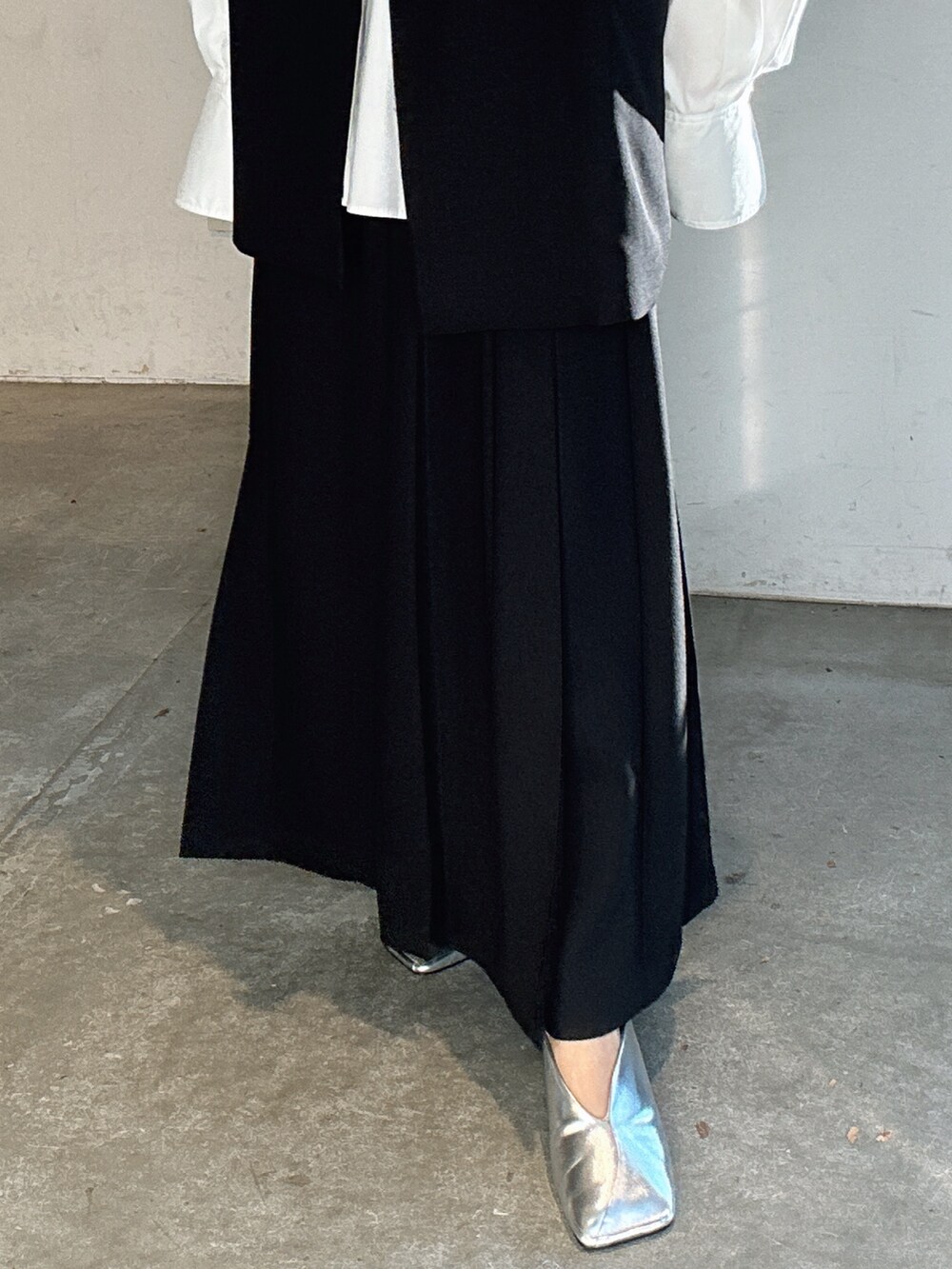 シルバー系のパンプス、ブラック系のテーラードジャケット、ブラック系のスカートを着用したレディースの冬コーディネートの10枚目の写真