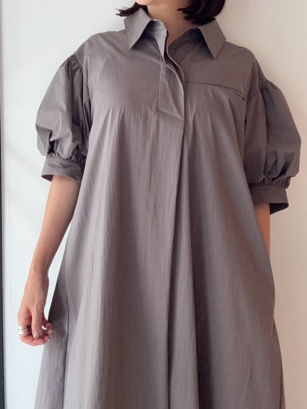 グレー系のワンピース、シルバー系のパンプス、レッド系のショルダーバッグを着用したレディースの夏コーディネートの5枚目の写真