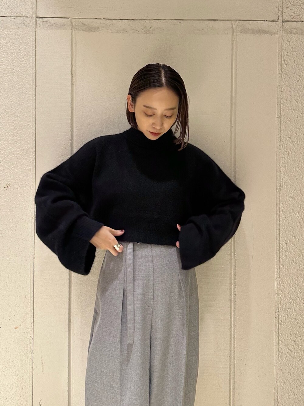 ブラック系のニット/セーター、グレー系のその他パンツ、ブラック系のブーツを着用したレディースの冬コーディネートの7枚目の写真