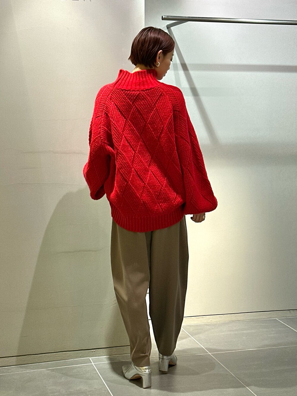 レッド系のニット/セーター、ブラウン系のその他パンツ、シルバー系のブーツを着用したレディースの秋コーディネートの5枚目の写真