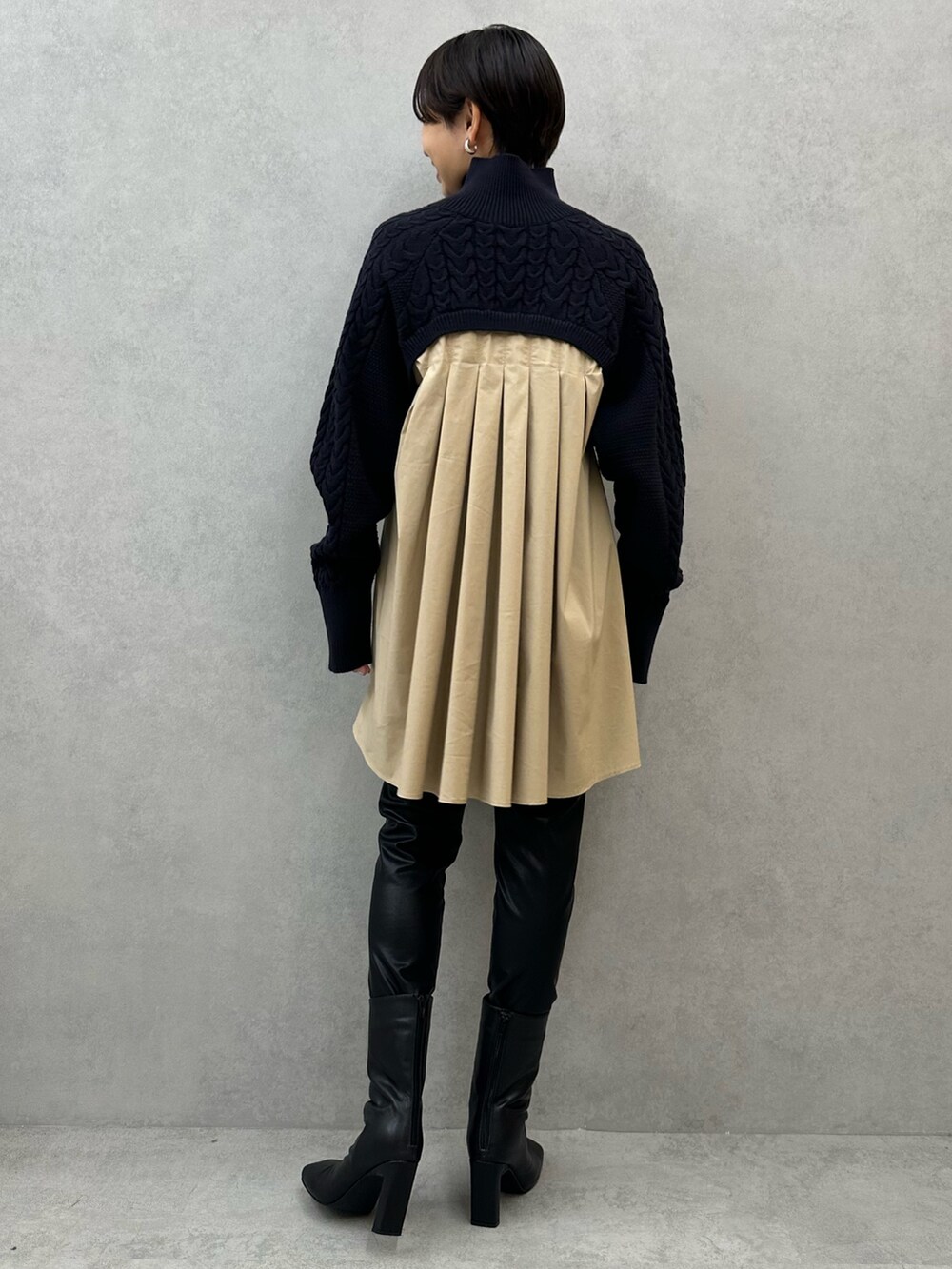 ブルー系のニット/セーター、ブラック系のその他パンツ、ブラック系のブーツを着用したレディースの秋コーディネートの3枚目の写真