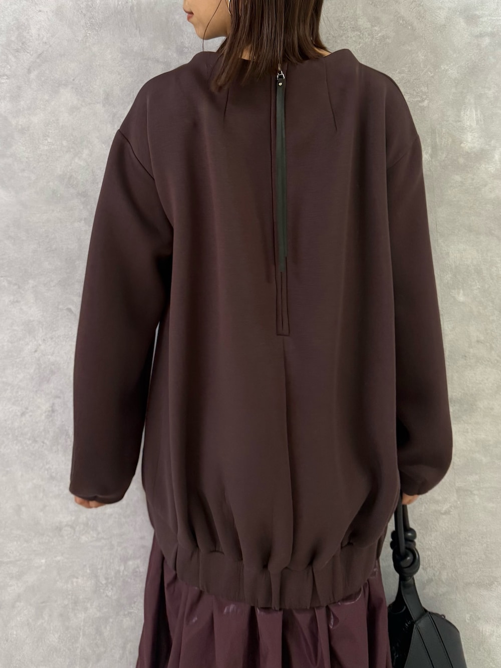 ブラウン系のワンピース、ブラック系のハンドバッグを着用したレディースの秋コーディネートの7枚目の写真