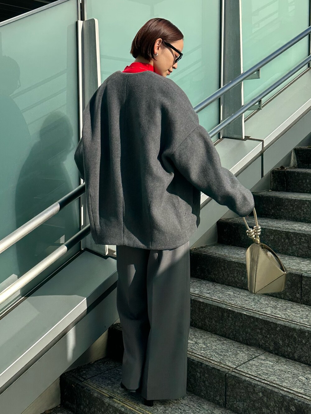 ブラック系のブーツ、グレー系のノーカラージャケット、レッド系のニット/セーターを着用したレディースの冬コーディネートの3枚目の写真