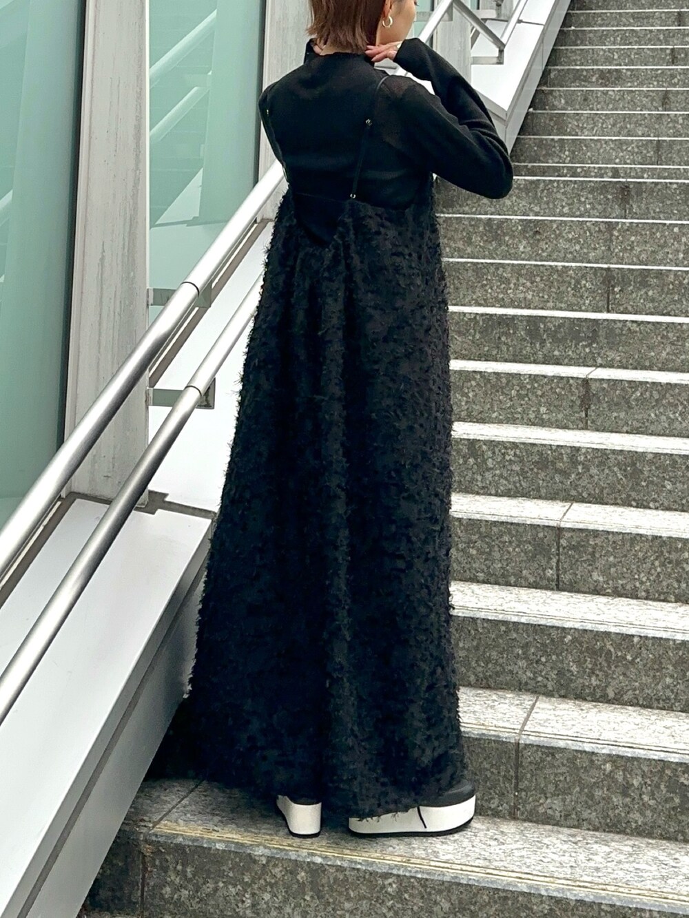 ブラック系のスニーカー、ブラック系のワンピース、ブラック系のニット/セーターを着用したレディースの冬コーディネートの5枚目の写真