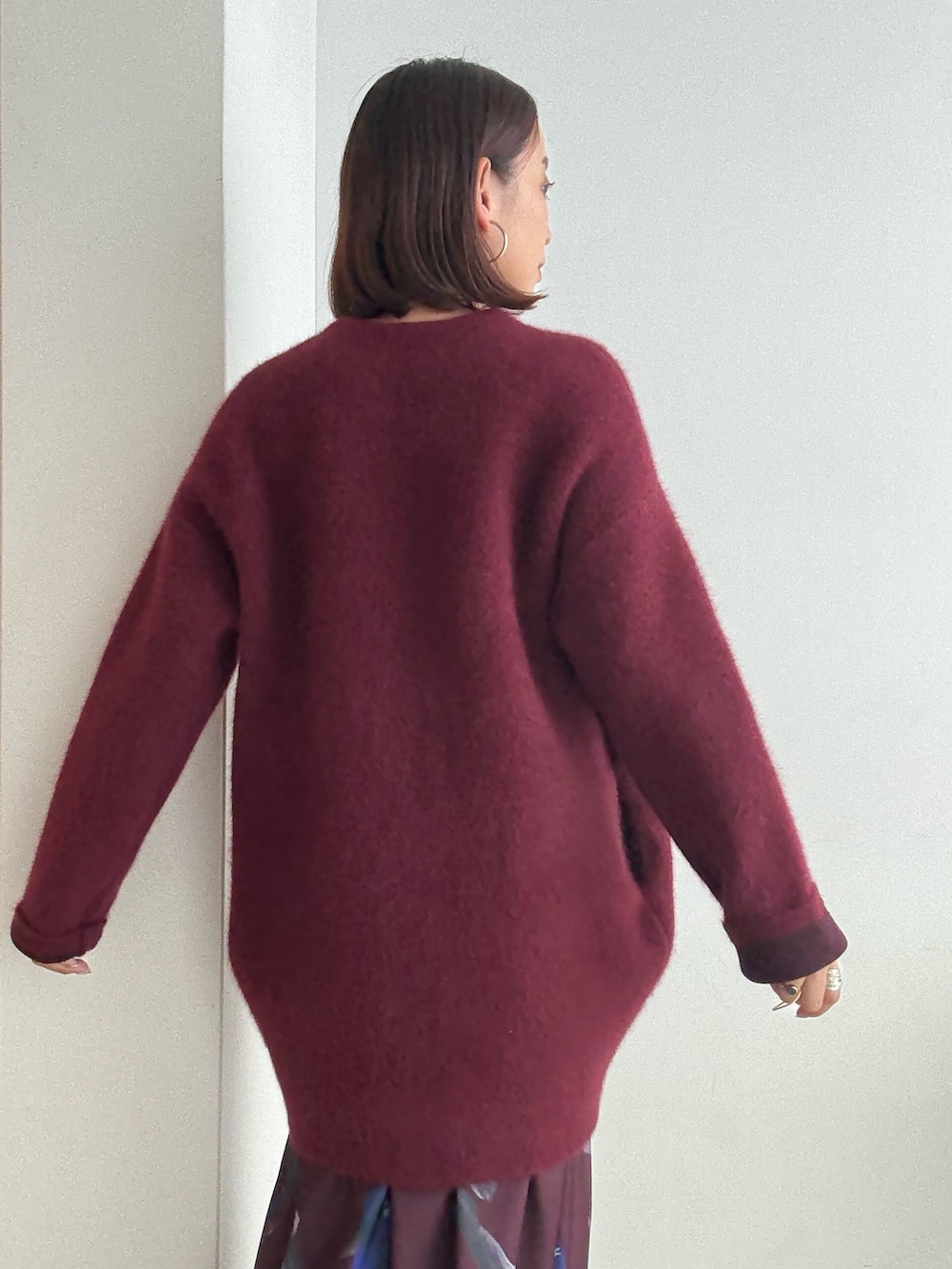 レッド系のスカート、レッド系のカーディガン/ボレロ、ブラック系のブーツを着用したレディースの夏コーディネートの7枚目の写真