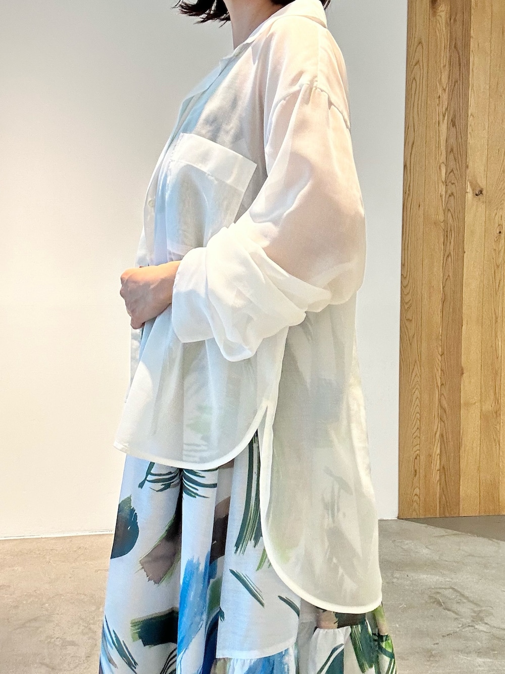 グリーン系のワンピース、ホワイト系のサンダル、ホワイト系のショルダーバッグを着用したレディースの春コーディネートの4枚目の写真