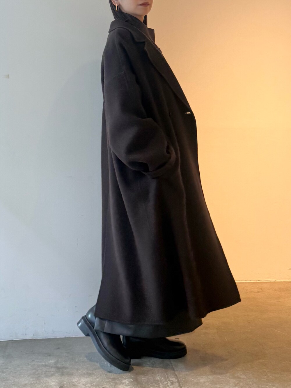 ブラウン系のチェスターコート、ブラック系のスカート、ブラウン系のニット/セーターを着用したレディースの秋コーディネートの3枚目の写真