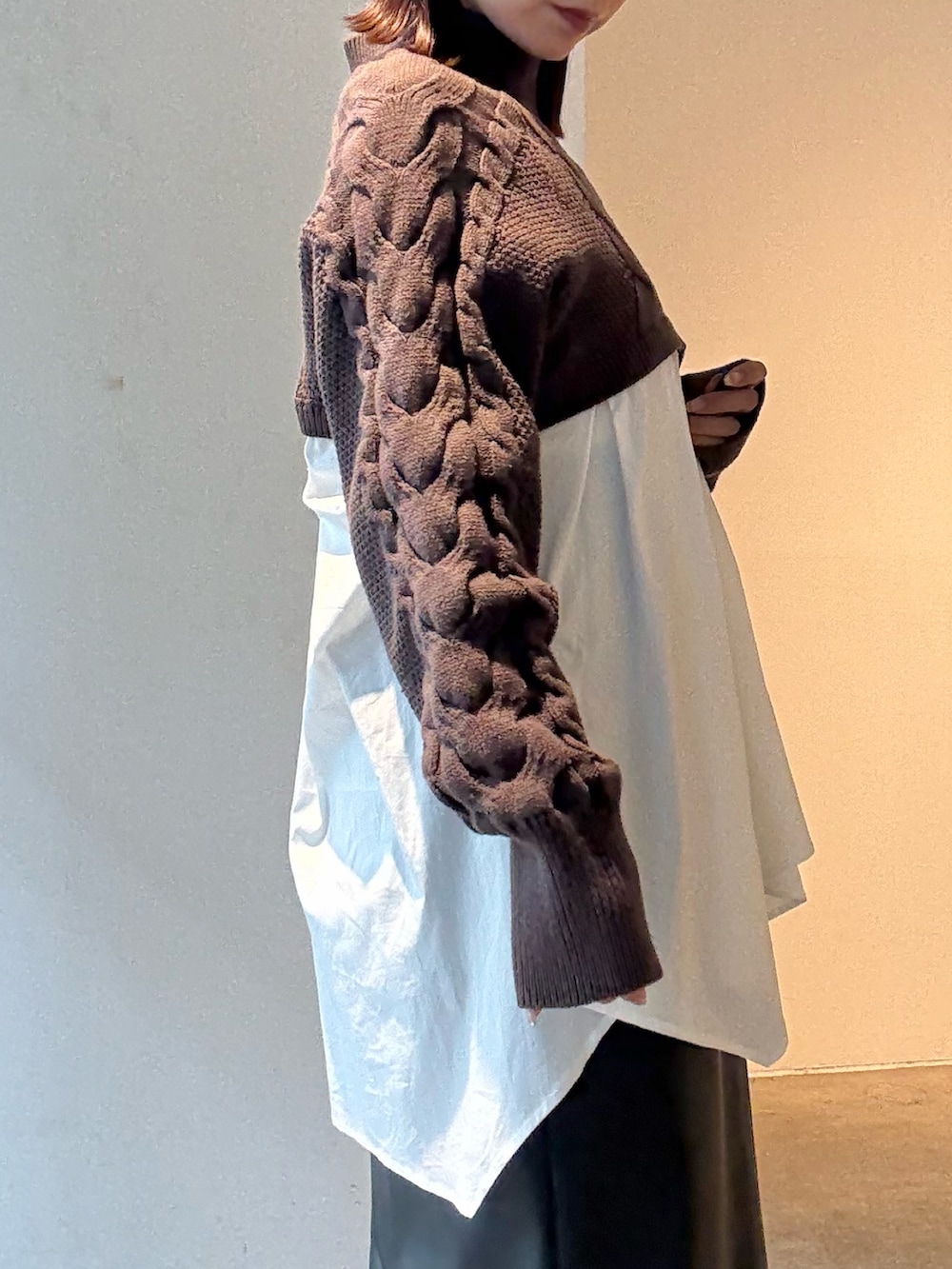 ブラック系のスカート、ブラウン系のニット/セーターを着用したレディースの秋コーディネートの5枚目の写真