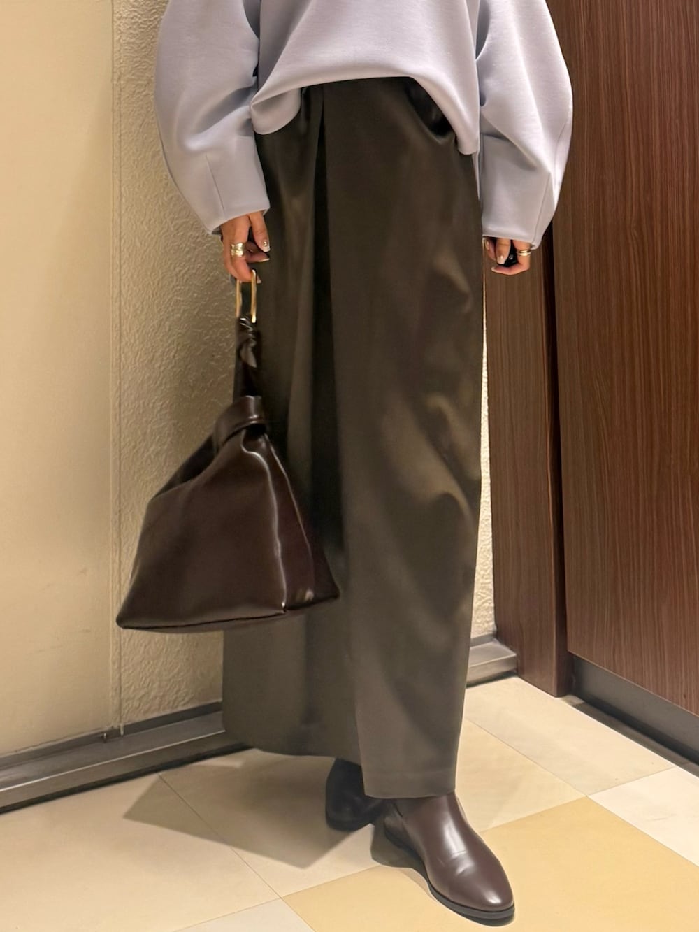 ブルー系のTシャツ/カットソー、ブラウン系のスカート、ブラウン系のブーツを着用したレディースの冬コーディネートの10枚目の写真