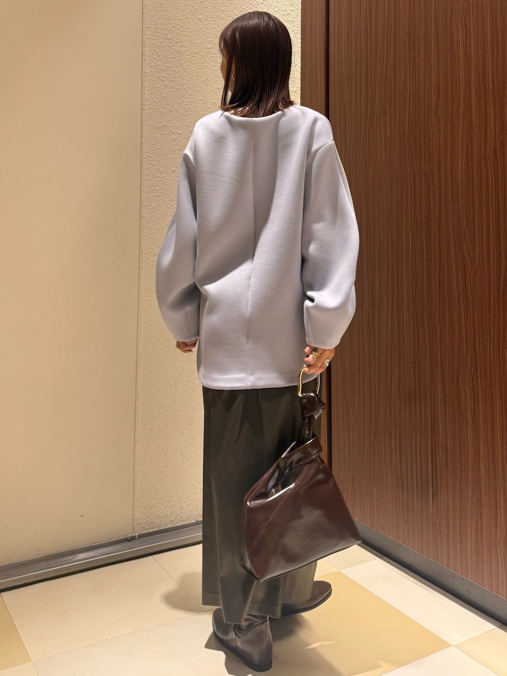 ブルー系のTシャツ/カットソー、ブラウン系のスカート、ブラウン系のブーツを着用したレディースの冬コーディネートの5枚目の写真