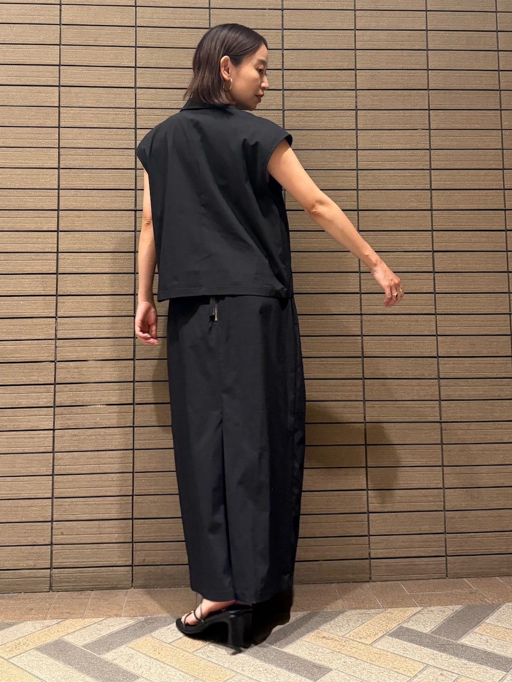 ブラック系のシャツ/ブラウス、ブラック系のスカート、ブラック系のサンダルを着用したレディースの夏コーディネートの6枚目の写真