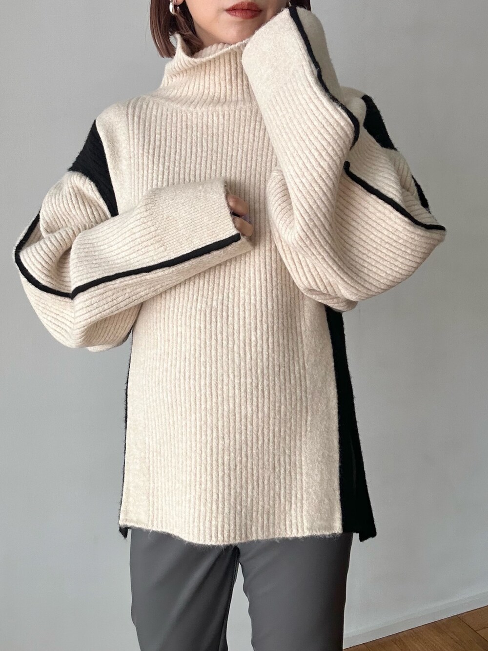 ホワイト系のニット/セーター、グレー系のその他パンツ、ブラック系のブーツを着用したレディースの秋コーディネートの10枚目の写真