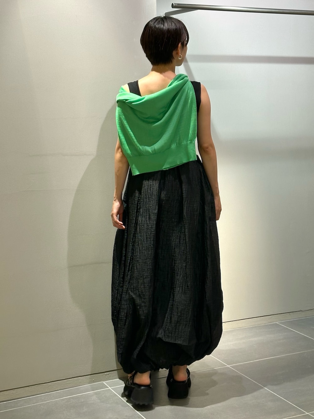 ブラック系のワンピース、ブラック系のサンダル、グリーン系のカーディガン/ボレロを着用したレディースの夏コーディネートの6枚目の写真