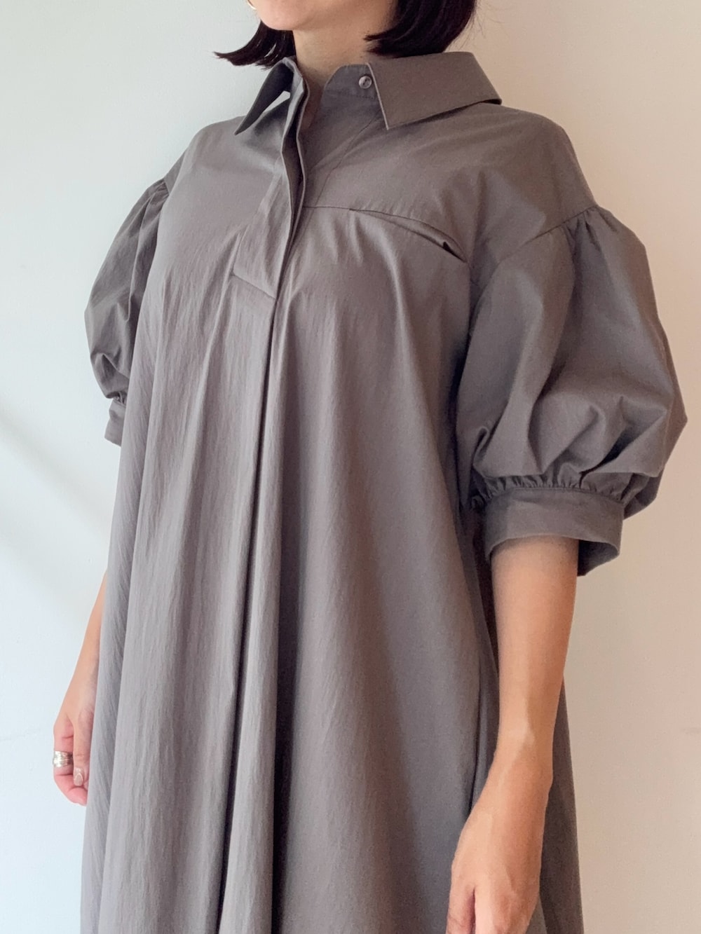 グレー系のワンピース、シルバー系のパンプス、レッド系のショルダーバッグを着用したレディースの夏コーディネートの4枚目の写真