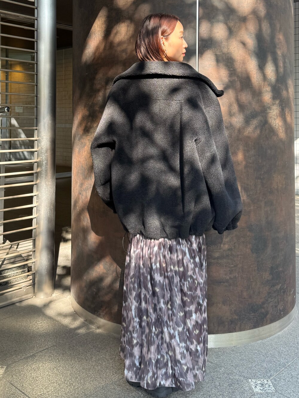 ブラウン系のワンピース、ブラック系のその他アウターを着用したレディースの秋コーディネートの3枚目の写真