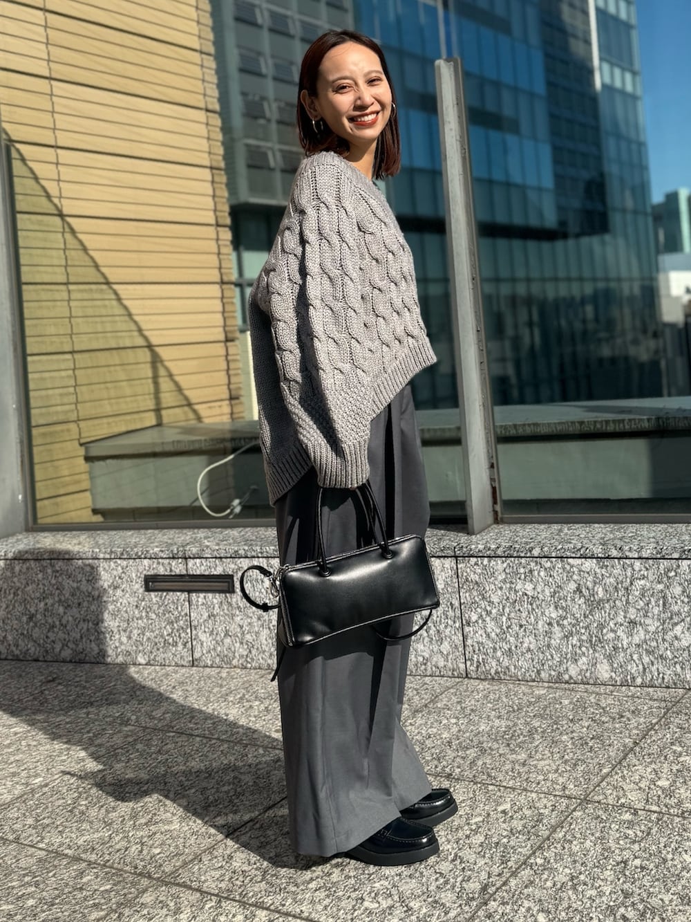 グレー系のその他パンツ、グレー系のニット/セーター、ブラック系のローファーを着用したレディースの冬コーディネートの2枚目の写真