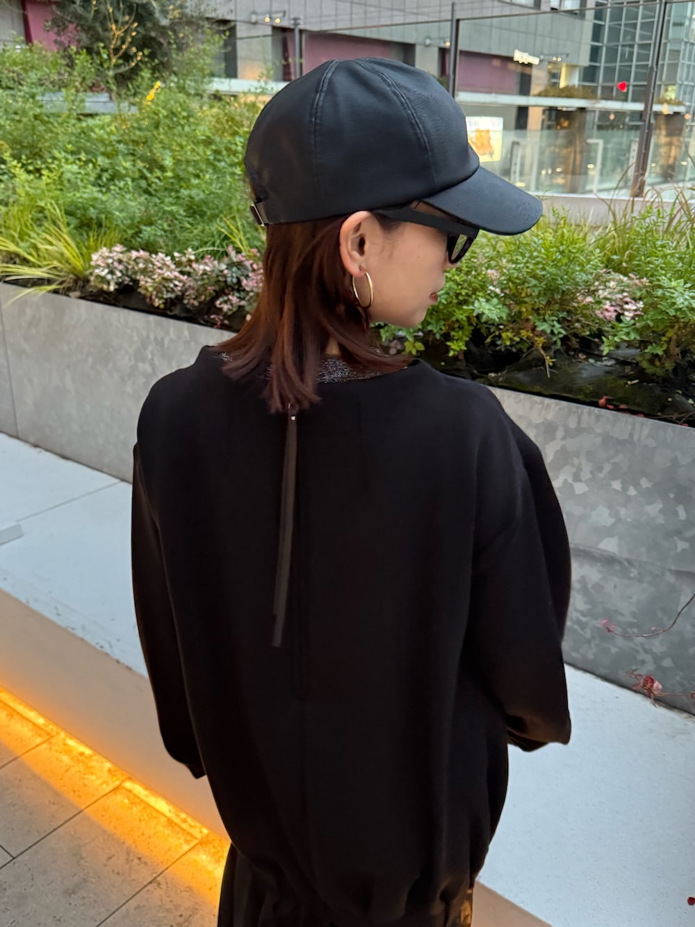 ブラック系のワンピース、ブラック系のブーツ、ブラック系のキャップを着用したレディースの冬コーディネートの4枚目の写真