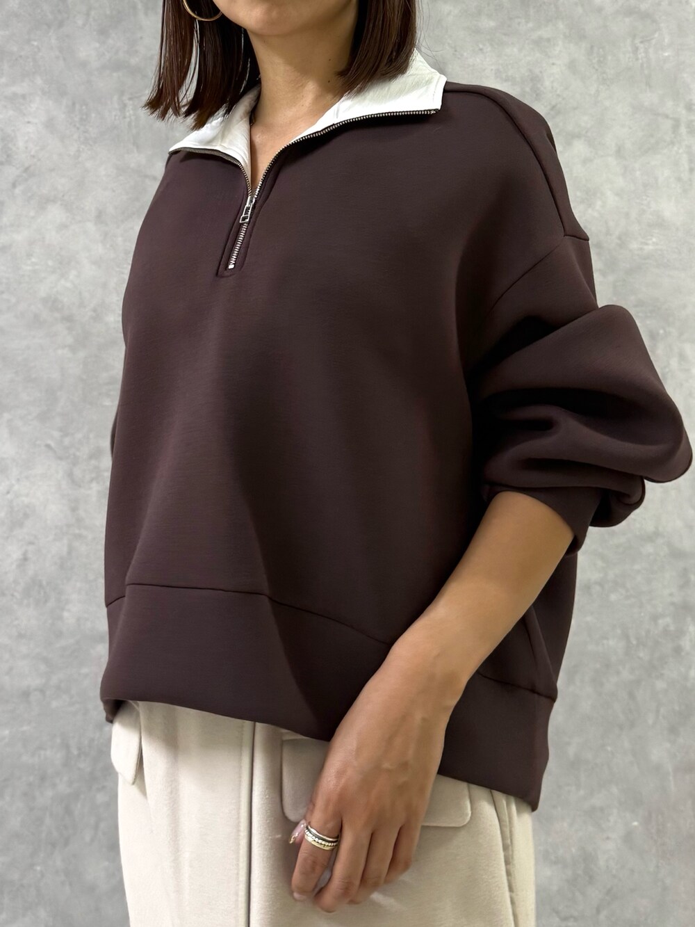 ブラウン系のTシャツ/カットソー、ホワイト系のスカート、ブラウン系のブーツを着用したレディースの秋コーディネートの4枚目の写真