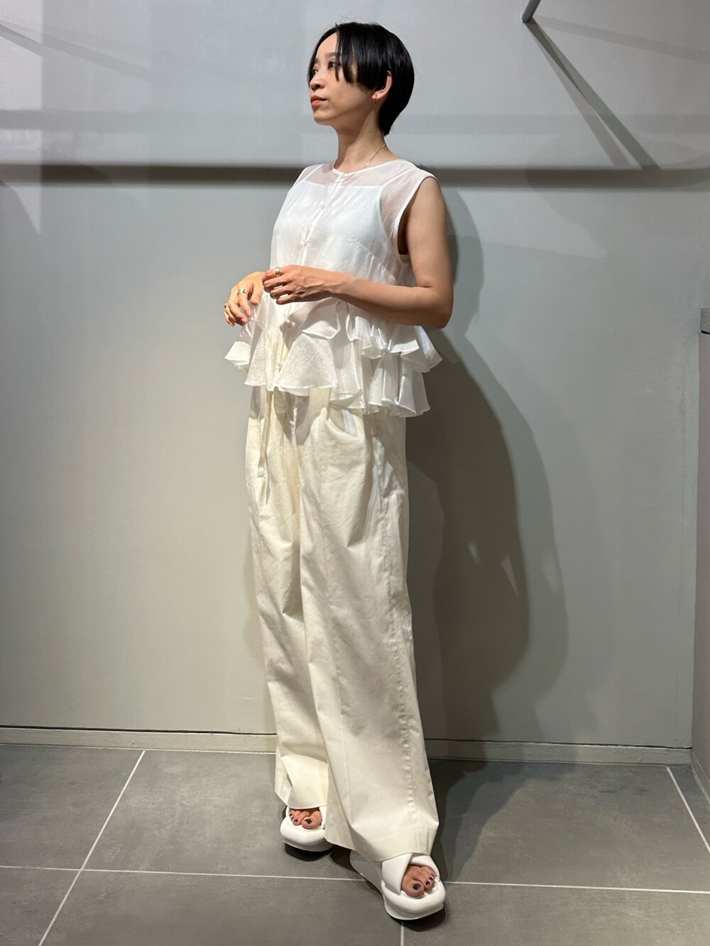 ホワイト系のサンダル、ホワイト系のその他パンツ、ホワイト系のシャツ/ブラウスを着用したレディースの春コーディネートの3枚目の写真