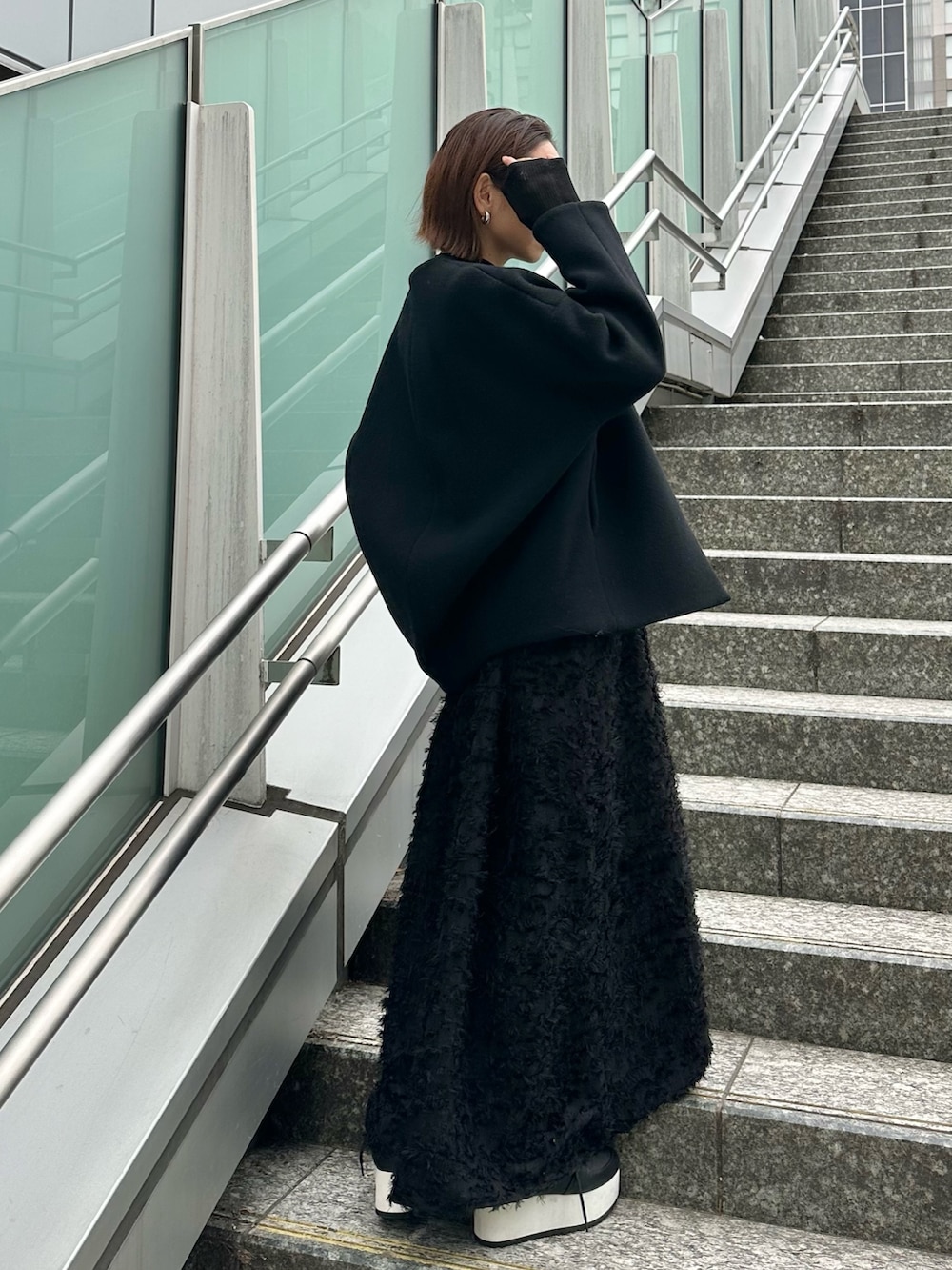 ブラック系のスニーカー、ブラック系のワンピース、ブラック系のニット/セーターを着用したレディースの冬コーディネートの7枚目の写真