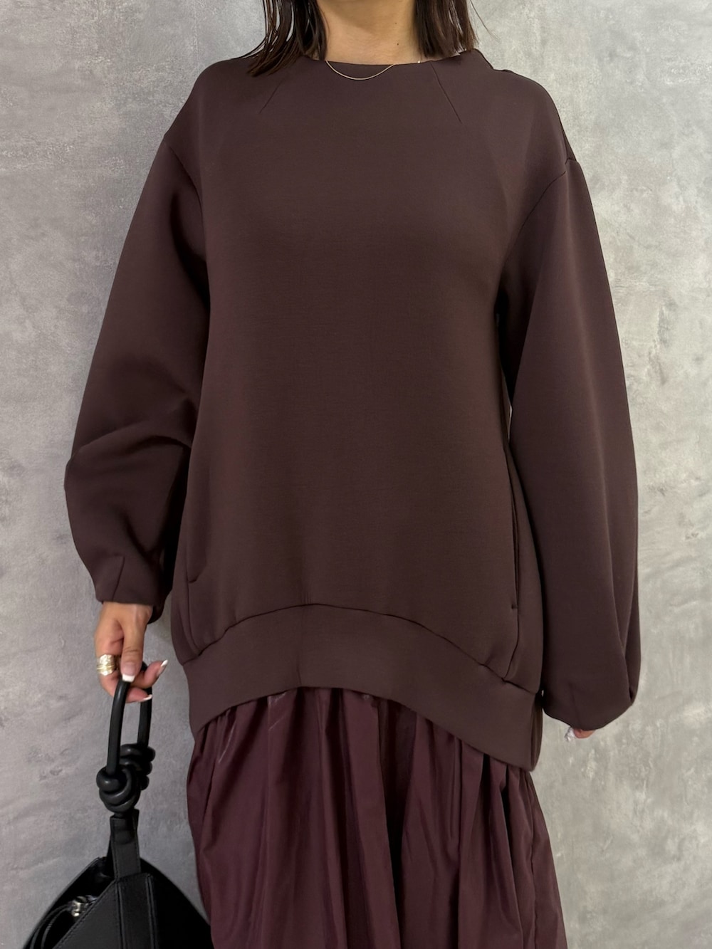 ブラウン系のワンピース、ブラック系のハンドバッグを着用したレディースの秋コーディネートの5枚目の写真