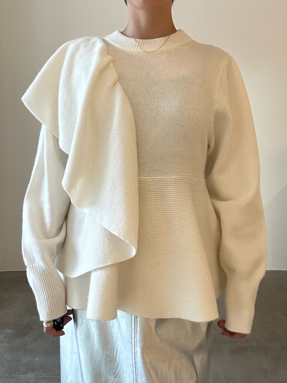 ホワイト系のニット/セーター、ブラック系のブーツ、シルバー系のスカートを着用したレディースの秋コーディネートの8枚目の写真