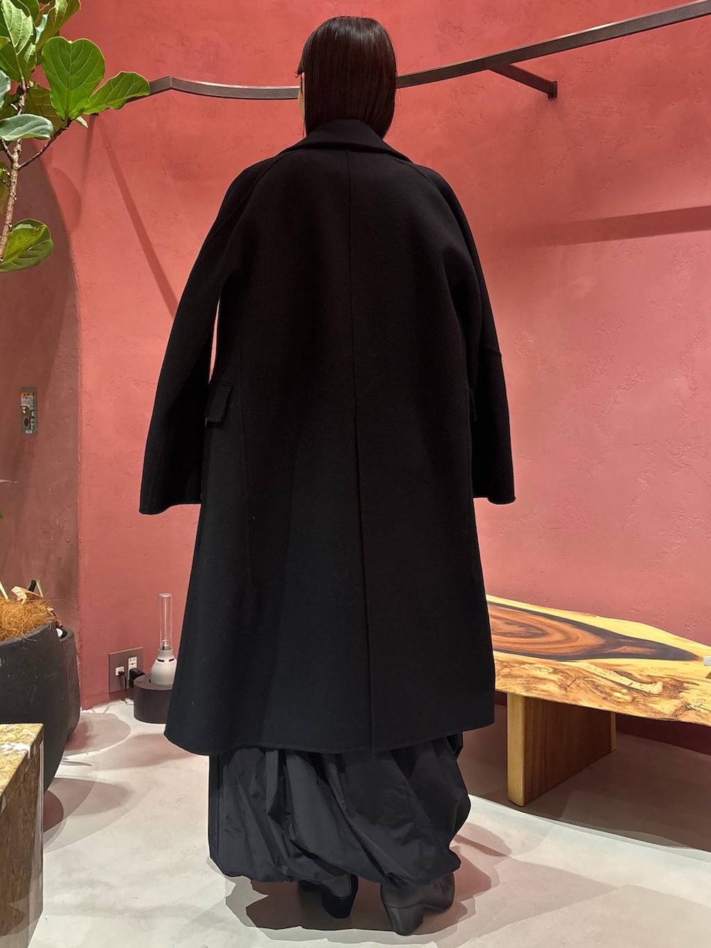 グレー系のニット/セーター、ホワイト系のTシャツ/カットソー、ブラック系のチェスターコートを着用したレディースの秋コーディネートの5枚目の写真