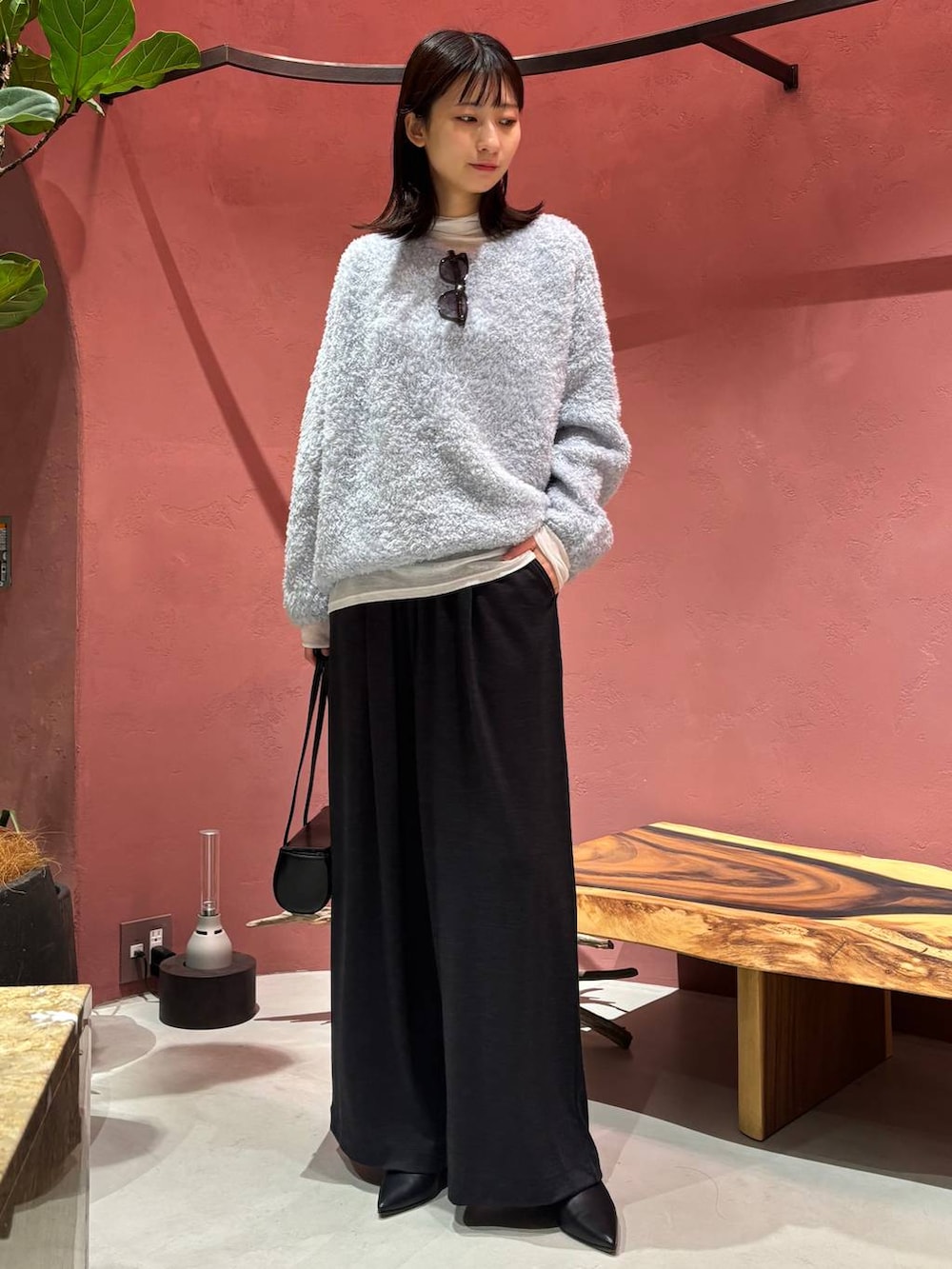 ブルー系のニット/セーター、ブラック系のノーカラーコート、ホワイト系のその他トップスを着用したレディースの秋コーディネートの5枚目の写真