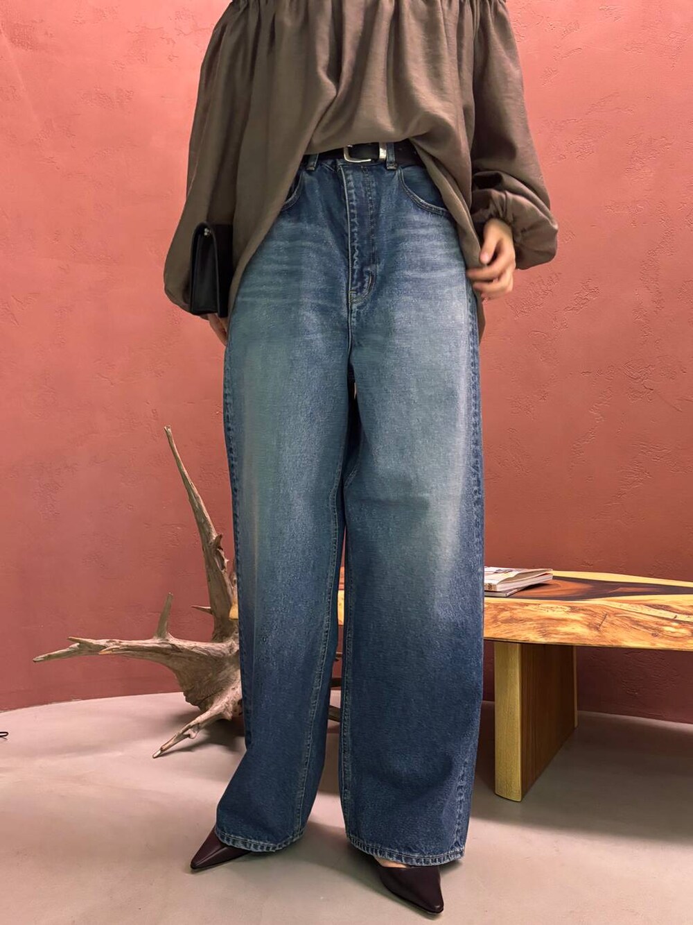 ブルー系のデニムパンツ、ブラック系のベルトを着用したレディースの秋コーディネートの7枚目の写真