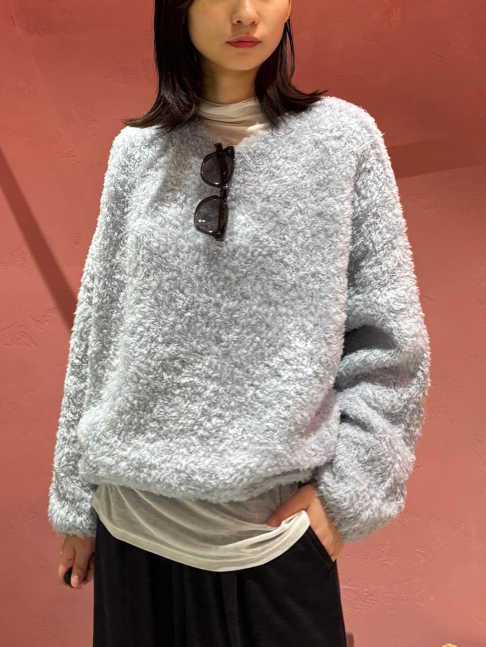 ブルー系のニット/セーター、ブラック系のノーカラーコート、ホワイト系のその他トップスを着用したレディースの秋コーディネートの7枚目の写真