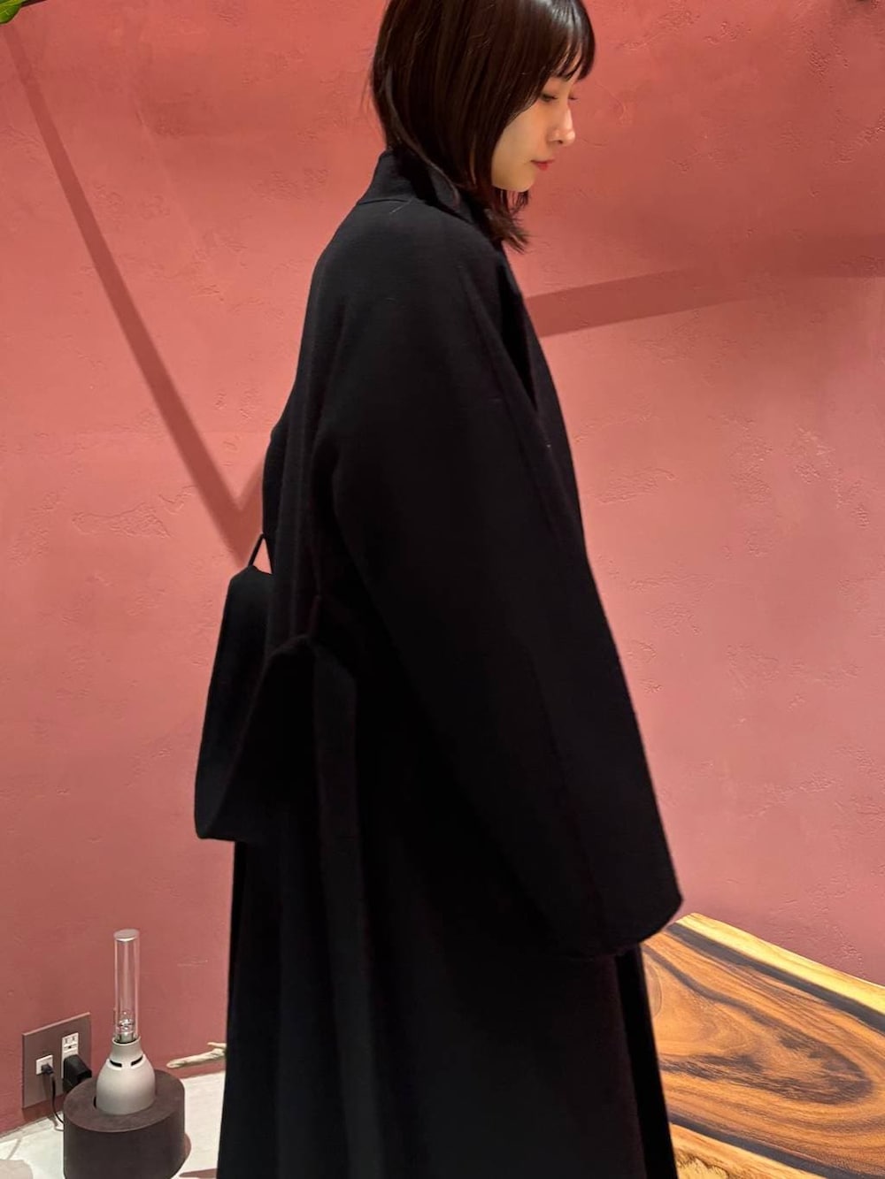 ブルー系のニット/セーター、ブラック系のノーカラーコート、ホワイト系のその他トップスを着用したレディースの秋コーディネートの4枚目の写真