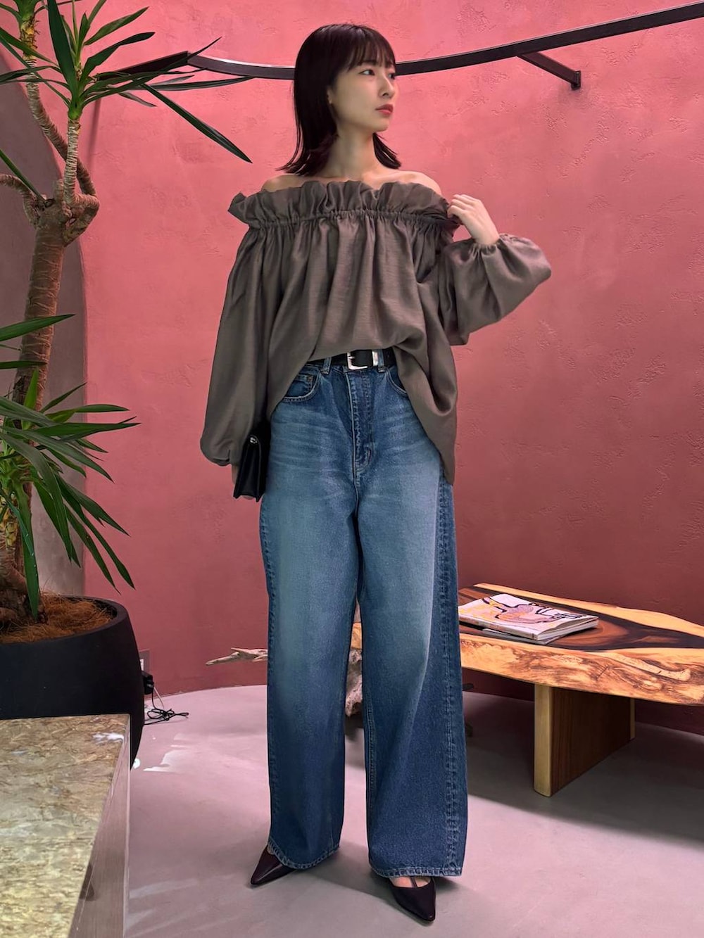 ブルー系のデニムパンツ、ブラック系のベルトを着用したレディースの秋コーディネートの2枚目の写真