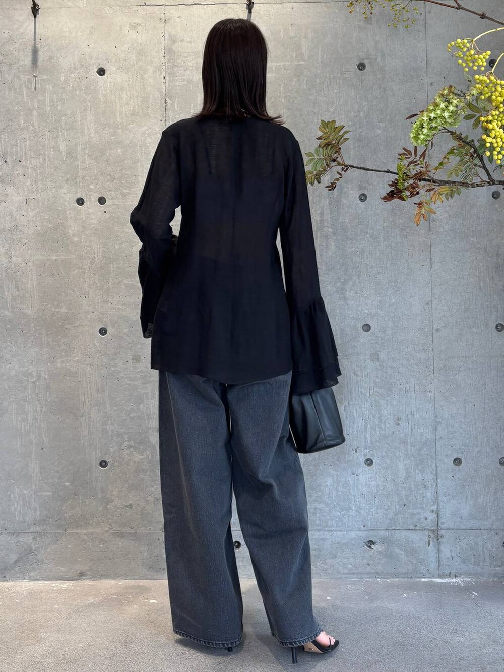 グレー系のチューブトップ、ブラック系のデニムパンツ、ブルー系のニット/セーターを着用したレディースの夏コーディネートの3枚目の写真